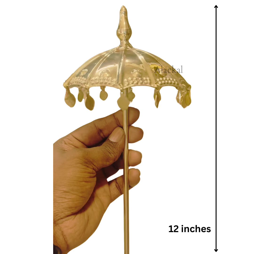 Beautifully crafted brass temple umbrella placed on a deity idol in a temple pooja setup